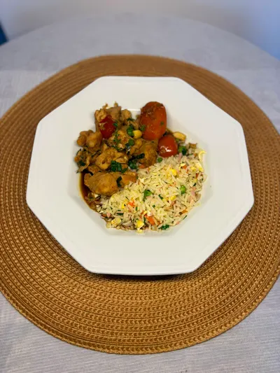 Prato de frango com legumes e arroz servido à mesa